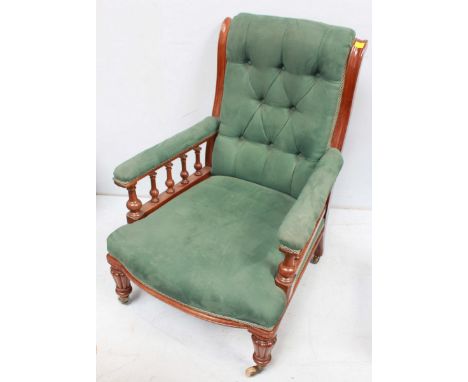 A Victorian mahogany button back armchair, with turned open arms, padded back, seat and arms covered  in green suede and supp