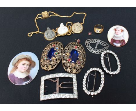A group of assorted jewellery including a carved lava cameo type necklace, various belt buckles, a porcelain painted miniatur