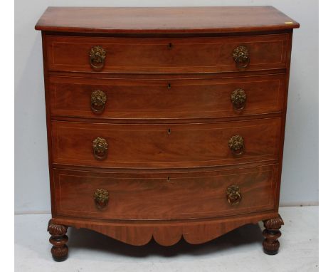 A 19th century mahogany bow front chest of drawers, with cross-banded top over four long graduated drawers, with brass ring h