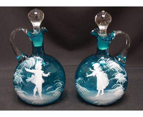A pair of Victorian Mary Gregory enamel painted turquoise glass jugs and stoppers. 24.5 cm high.