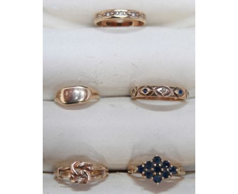 Two 9ct gold eternity rings, two signet rings and a dress ring claw-set with simulated blue sapphires