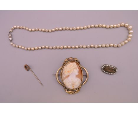 A cameo brooch, a pearl necklace, a mourning brooch and a horseshoe form stick pin.  Cameo brooch 6 cm high. 