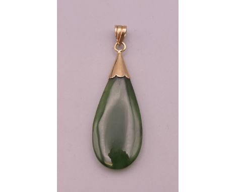 A gold mounted jade pendant.  4 cm high excluding suspension loop.