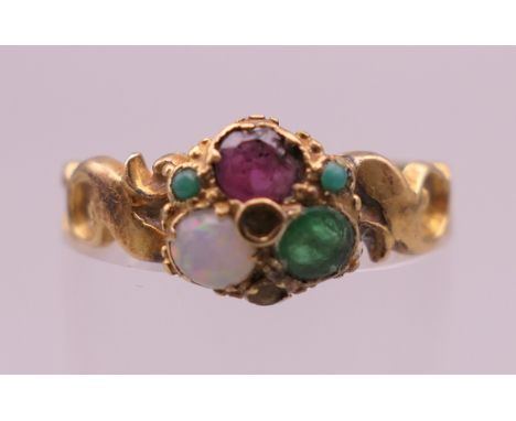 A Victorian unmarked gold opal, ruby and emerald ring. Ring size L/M. 2.2 grammes total weight.