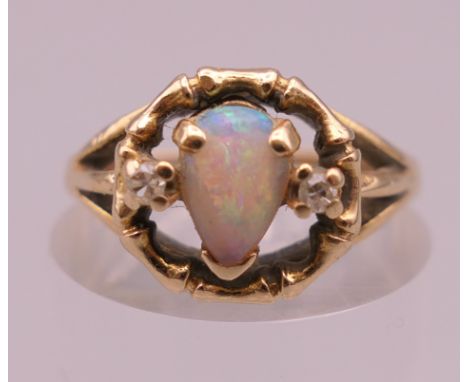 An unmarked gold, opal and diamond ring. Ring size M. 3.4 grammes total weight.