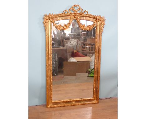 A 20th Century Wall Mirror with ribbon surmount, draped flowers and reeded frame, 4ft 9in H x 2ft 11in W 