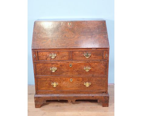 An 18th Century elm Bureau, the interior fitted cupboard, drawers, pigeon holes and well, above two dummy  and two long drawe