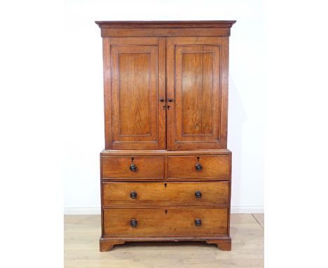 A 19th Century oak Linen Press with moulded cornice above a pair of panelled doors enclosing shelves, above two short and two
