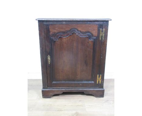 An antique oak Cupboard, the single door with fielded panel enclosing a shelf and panelled to the sides on bracket supports, 