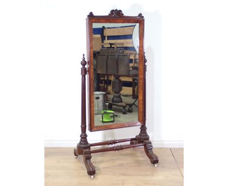 A 19th Century carved mahogany Cheval Mirror, the crest top looking glass on fluted uprights above shaped outswept legs and s