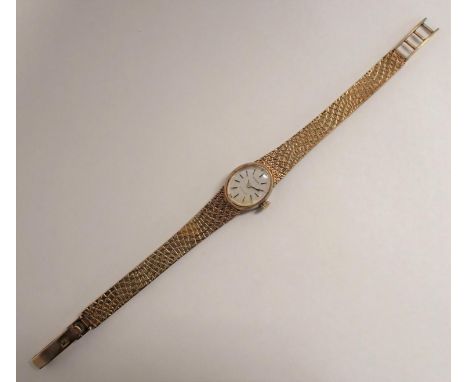 A 1970's lady's Tissot manual Wristwatch, the silvered oval dial with hourly baton markers on integral textured flexible brac