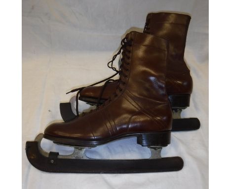 A pair of vintage brown leather ice skating boots, the soles stamped "Manfield" and the blade protectors "Mitchell & Co. Manc