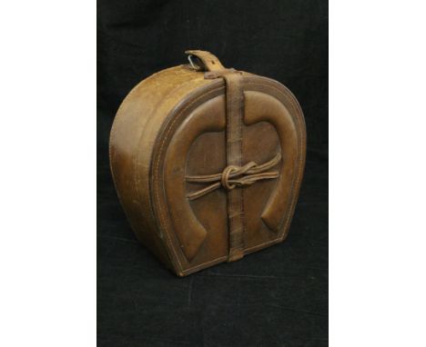 A vintage leather collar box in the form of a horseshoe with embossed horseshoe decoration to top, opening to reveal a fitted