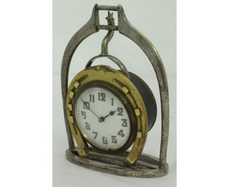 A mantle clock mounted as a horseshoe within a stirrup frame, the white enamel dial set with Arabic numerals, bears Victorian