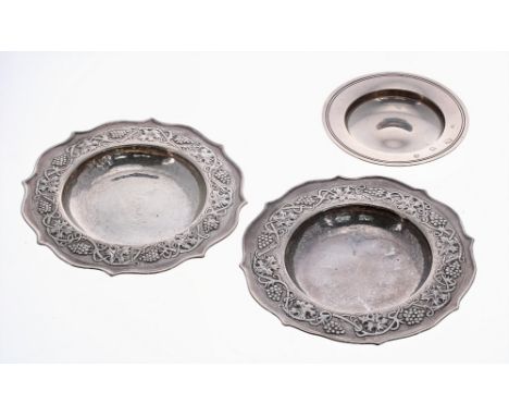 Pair of Keswick School of Industrial Art small planished silver dishes, with fruiting vine repousse borders within serpentine