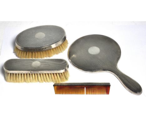 A George V hallmarked silver engine turned dressing table set to include mirror, two brushes and a comb. Birmingham 1927 (4).