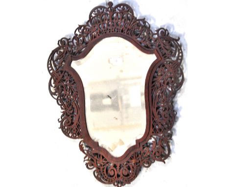 A fretwork decorated shaped wall mirror (af).