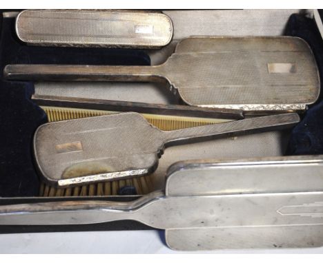 A cased hallmarked silver engine turned vanity set comprising two brushes, two hand mirrors and a comb, various hallmarks, le