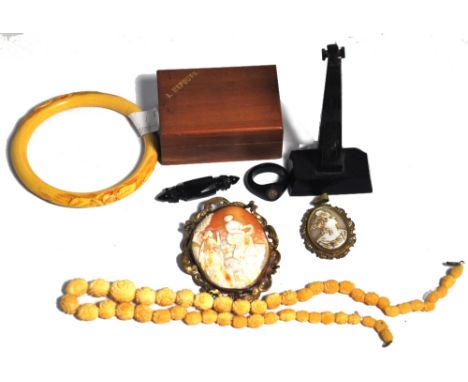 Three Pieces of Whitby jet to include a brooch, a ring with a yellow metal insignia intaglio to the top, a obelisk with cruci