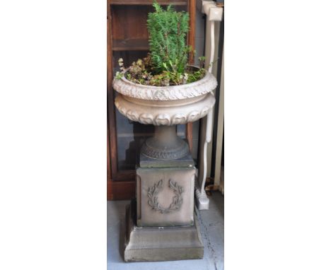 A large composite planter with classical decoration mounted on a square plinth, approx height 100cm.
