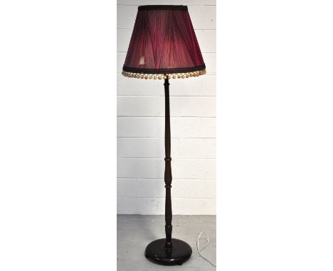 A mid 20th century mahogany standard lamp set on circular base with period damson shade, approx height 190cm.