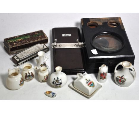 A collectors lot of Crested ware to include a glass milk pail, a vintage tie press, a M.Hohner mouth organ and a view finder 