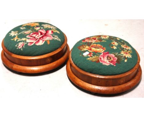 A pair of Edwardian walnut tapestry upholstered circular foot stools.