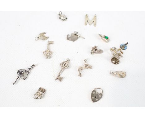 Fifteen vintage white metal charms. Including heart, boot and bell, etc.