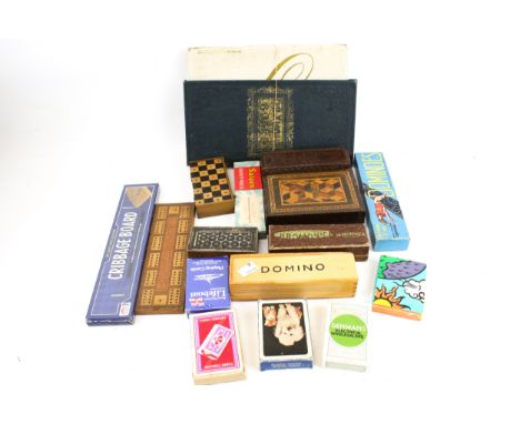 An assortment of vintage games. Including a set of Greyhound dominoes, a cribbage board, packs of cards, etc.