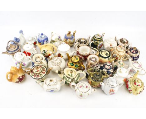 A collection of Griffin and other ceramic miniature teapots