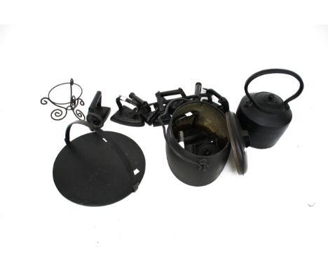 An assortment of vintage metal fireside items. Including a kettle, flat irons and a caldron, etc. Max. H35cm