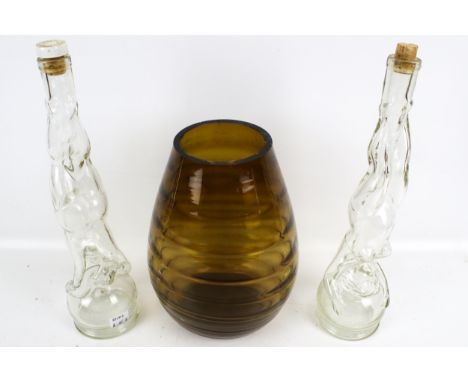 A vintage optic ribbed vase and two novelty French bottles. The bottles each in the form of a women standing on their heads, 