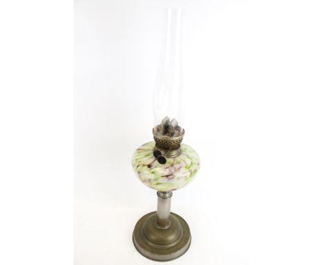 An early 20th century oil lamp. With a marbled glass reservoir, mounted on a brass stand with circular base, glass chimney, H