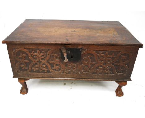A Victorian oak chest/coffer. The front with a carved panel, raised on ball and claw feet, H39cm x W74cm x D44cm