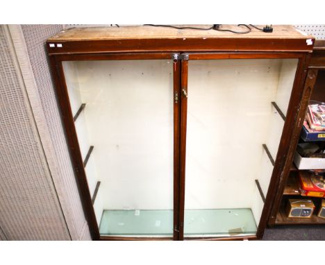 A vintage shop display cabinet. Wooden with two glazed doors, three glass shelves. L147cm x D34cm x H175cm