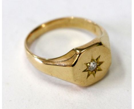 A GENTLEMAN'S YELLOW GOLD SIGNET RING inset with a diamond and star cut decoration to the top, mark rubbed and indistinct, si