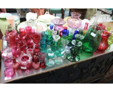 A COLLECTION OF CRANBERRY AND OTHER GLASSWARE to include wine glasses, vases, an old lamp, a pair of green glass candlesticks
