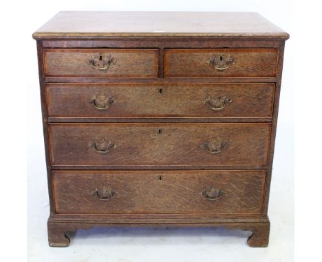 A LATE 19TH CENTURY OAK CHEST OF TWO SHORT AND THREE LONG DRAWERS with brass swan neck handles, standing on shaped bracket fe