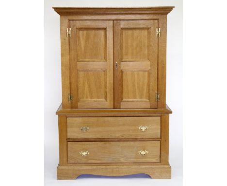 A LIGHT OAK CUPBOARD with twin doors above two drawers, raised on bracket feet, 105cm which x 60cm deep x 150cm high