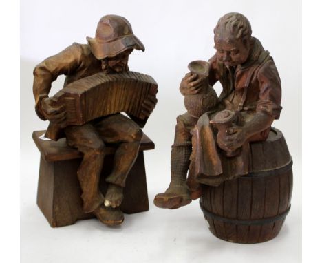 TWO ANTIQUE AUSTRIAN WOOD CARVINGS of two gentlemen seated, one playing an accordion, the other with jugs of ale, the tallest