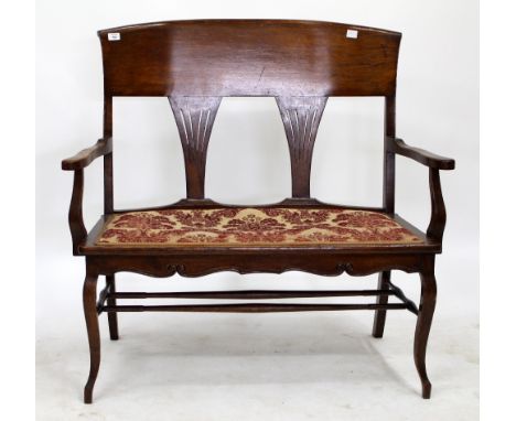 AN EARLY 20TH CENTURY OAK BENCH with two splat backs, open arms and cabriole legs, 103cm wide 