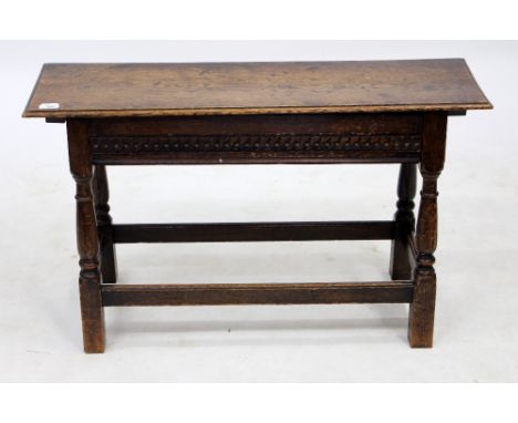 AN 18TH CENTURY STYLE OAK HALL BENCH with a lifting lid and turned supports united by stretchers, 91cm wide x 28cm deep x 53c