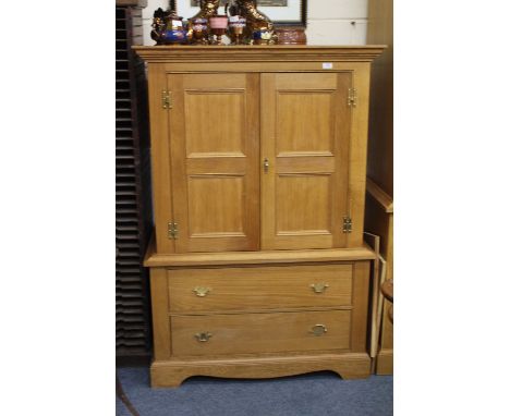 A PAIR OF LIGHT OAK CUPBOARDS each with twin doors above two long drawers and raised on bracket feet, 101cm wide x 60cm deep 