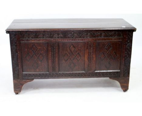 A LATE 17TH CENTURY OAK COFFER with a three panelled carved and inlaid front, raised on bracket feet, 134cm wide x 54cm deep 