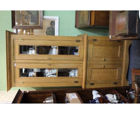 A LIGHT OAK CUPBOARD with twin glazed doors above twin panelled doors and raised on bracket feet, 92cm wide x 64cm deep x 204