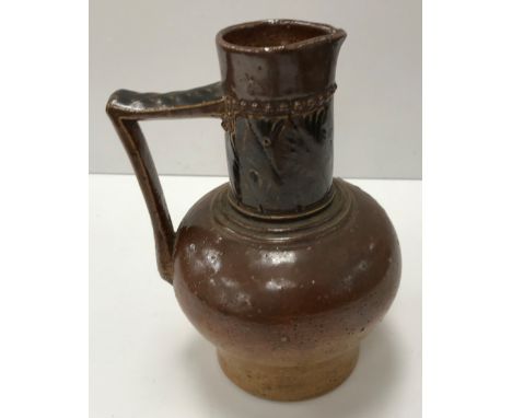 A late 19th Century Martin Brothers pottery jug with brown glaze and acanthus style decoration to neck, inscribed to base "R 