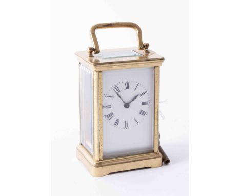 Antique brass carriage clock with white enamel face and black roman numeral markings, antique hands, in good working conditio