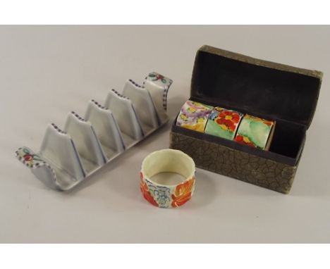POOLE POTTERY ETC.
A Poole Pottery toast rack, 16cm & a set of four hand painted pottery napkin rings in original box.