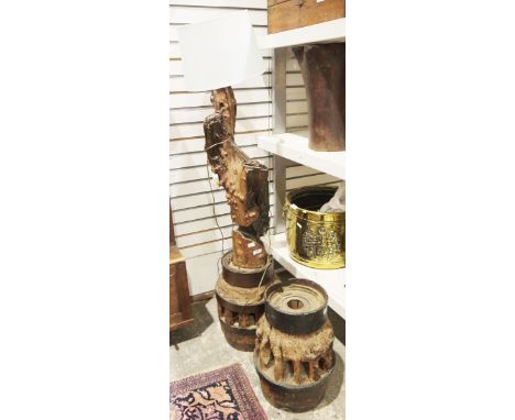 Two vintage wooden mounted cart hubs, one adapted as a floor lamp, issuing from a tree stump base, 125cm high max. inc. shade