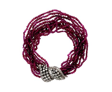 170 BRACCIALE IN RUBINI E DIAMANTI , 1950 CIRCA a 10 fili di piccole sfere di rubini con chiusura in oro bianco e diamanti di